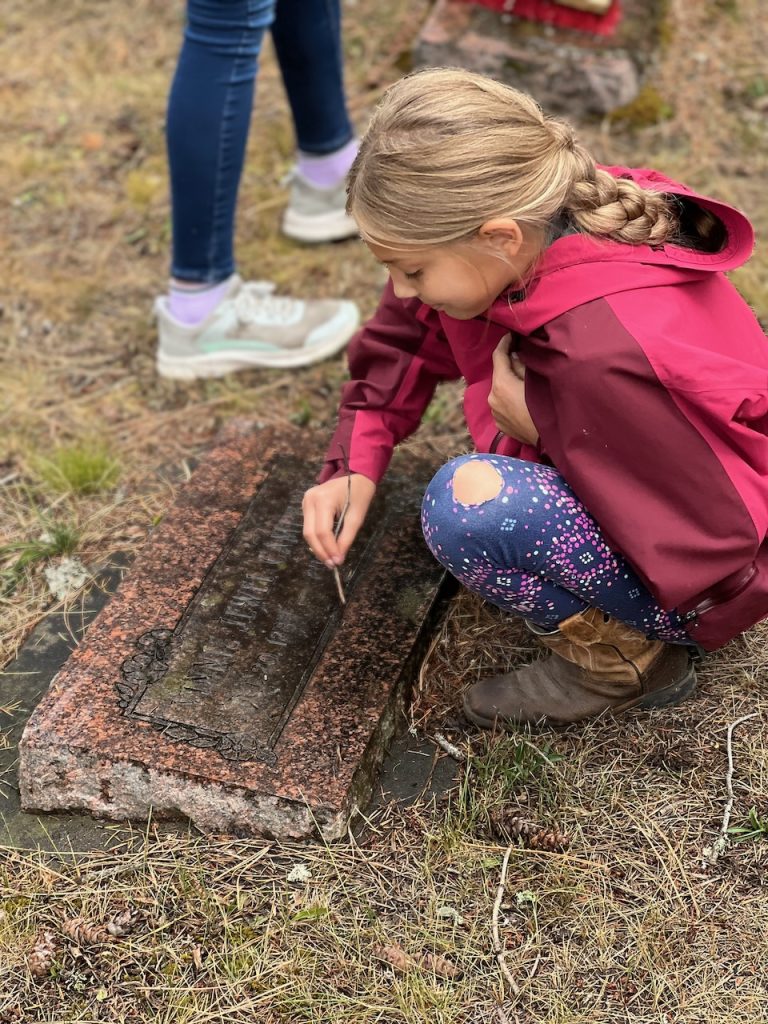 A young volunteer cleaning a grave marker