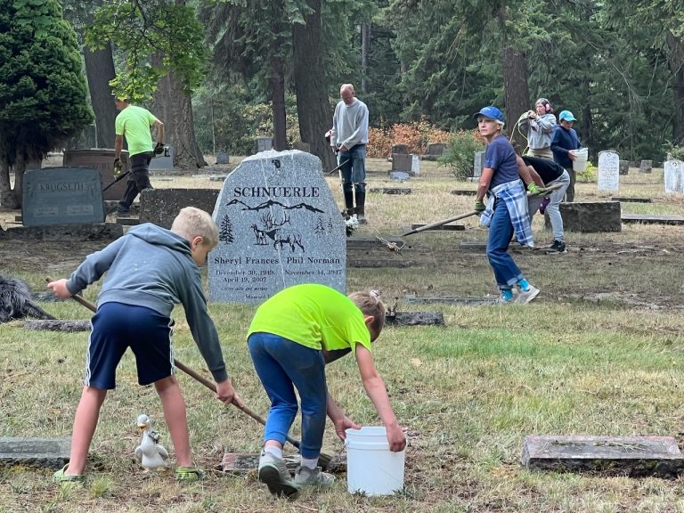 Volunteers cleaning headstones in the old section