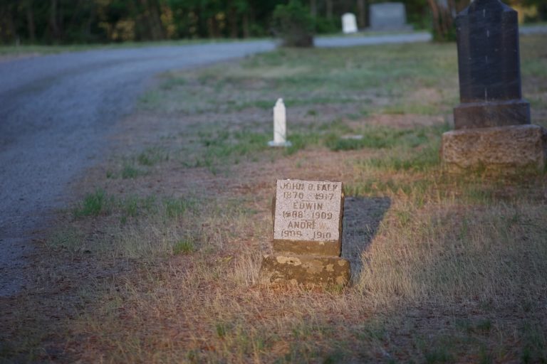 A small weathered grave marker beside the lane